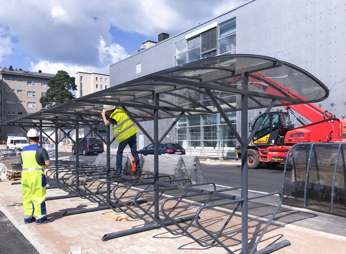 Two workers installing BikeKeeper Dual Side Shelter